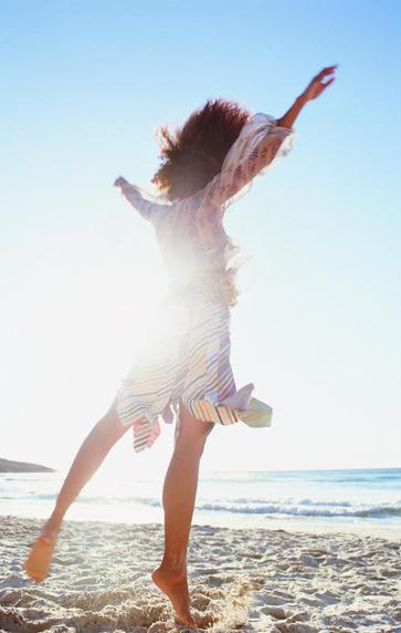 Loving life, girl jumping at tthe beach